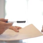 Inclusive Policy - Crop businessman giving contract to woman to sign