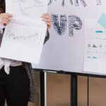 Financial Goals - Woman in Gray Coat Holding White Printer Paper